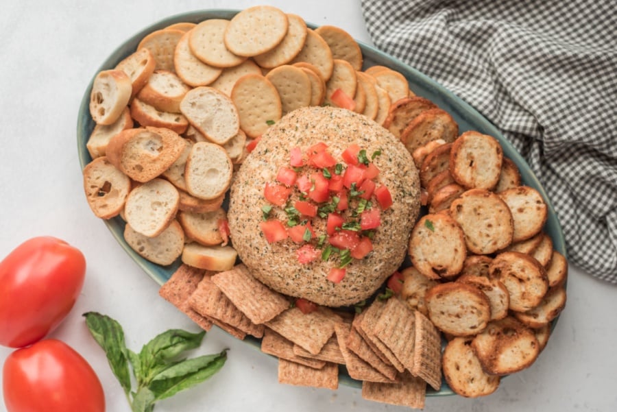 Bruschetta Cheese Ball on a plate with crackers