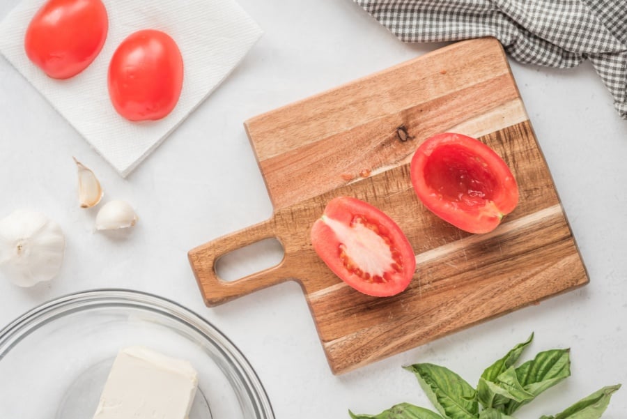tomato cut in half on cutting board