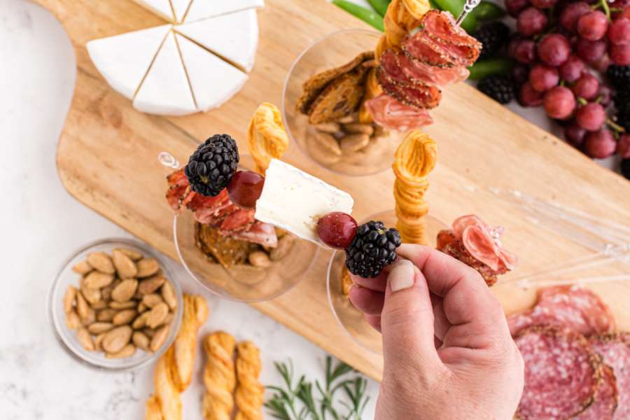 adding berries and cheese to another skewer