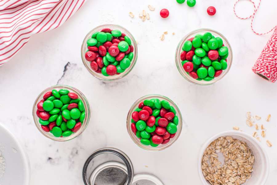 adding green and read m&ms on top of cookie mix