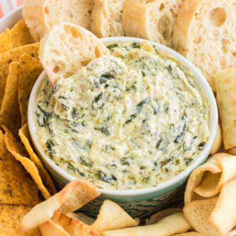 Instant Pot Spinach Artichoke Dip in a bowl with bread slices