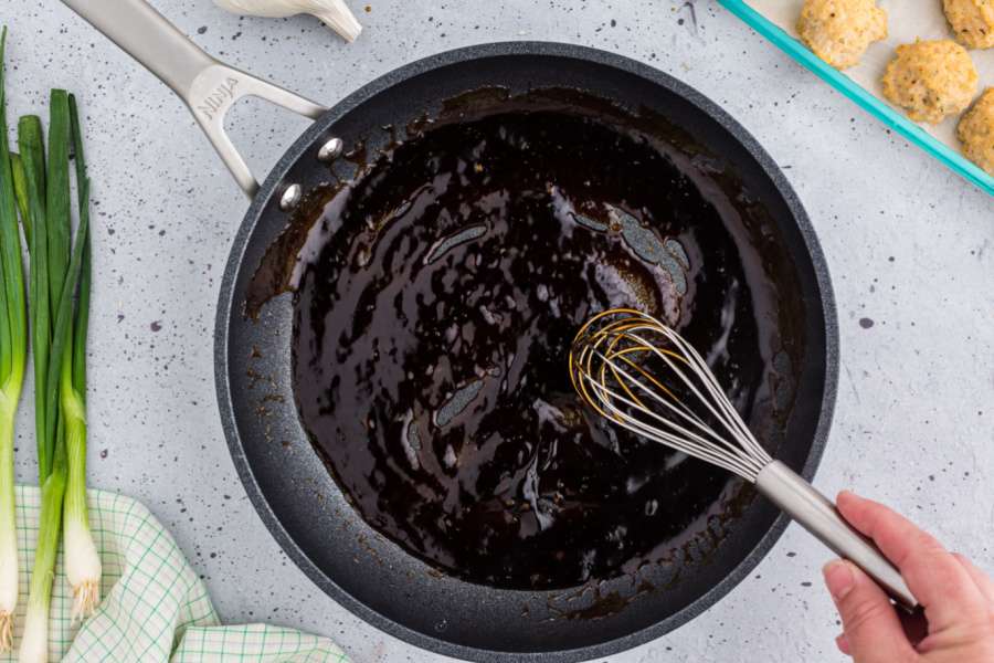 mixing sauce in pan with whisk