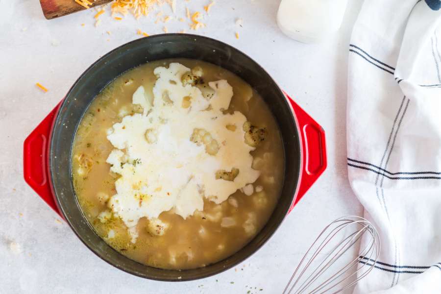 adding cream mixture to soup