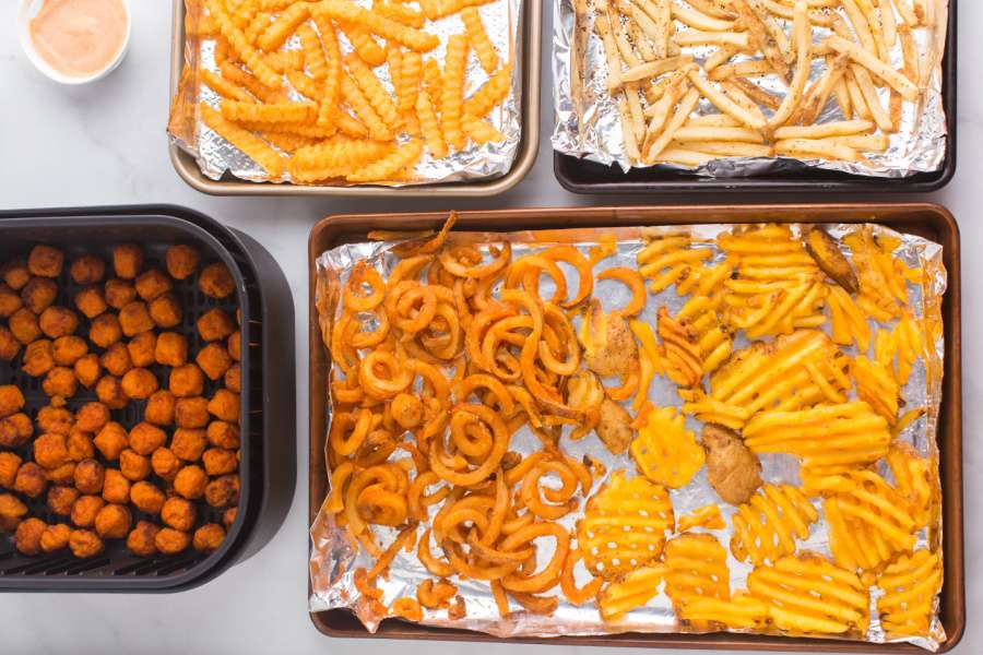 french fries on baking sheets and tater tots in air fryer