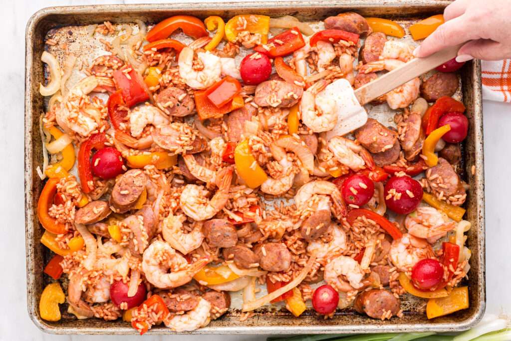 stirring sheet pan jambalaya with spatula 