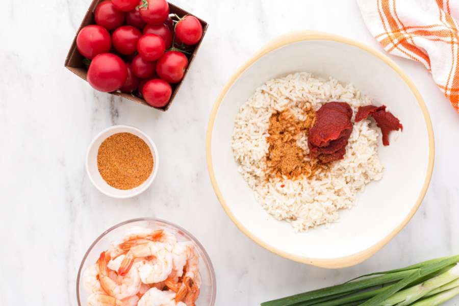 adding seasoning and tomato past to rice