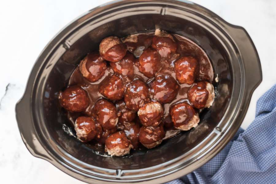 sauce poured over meatballs in slow cooker