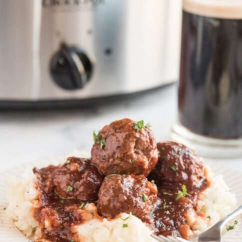 Crockpot Guinness Glazed Meatballs on a plate with mashed potatoes