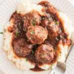 Crockpot Guinness Glazed Meatballs on a plate with mashed potatoes