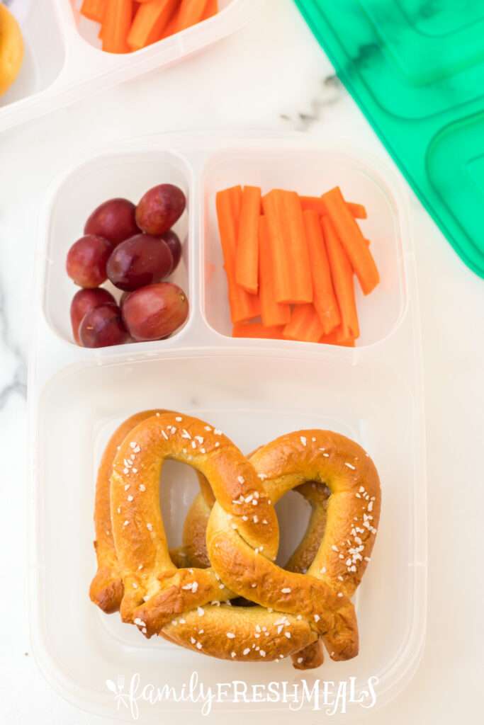 soft pretzels, grapes and carrots packed in a lunchbox