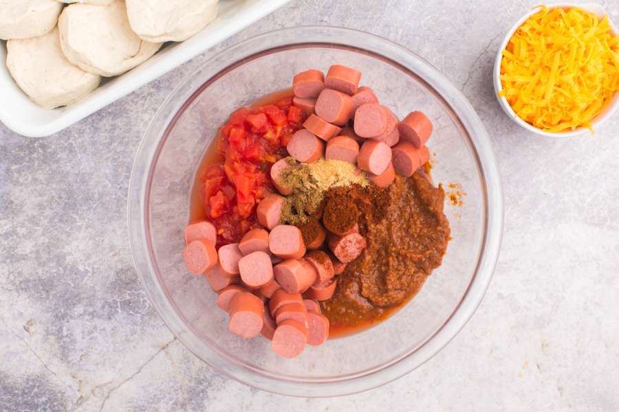hot dogs, chili sauce, tomatoes, and seasonings in a large bowl