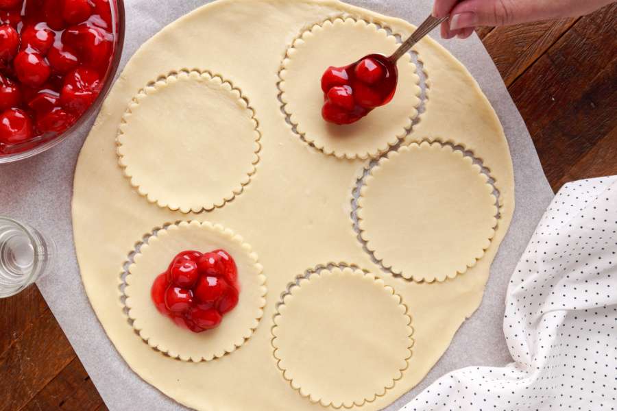 putting cherry filling on pastry
