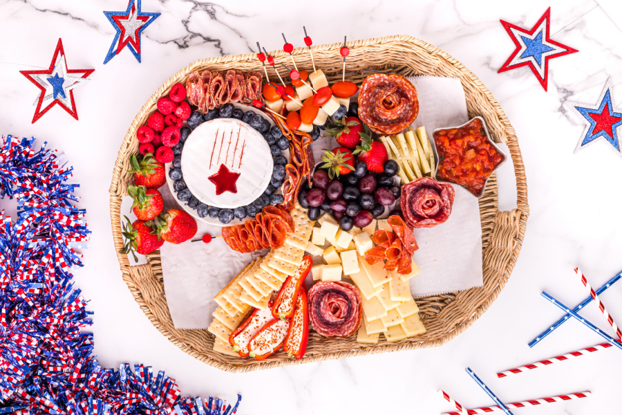 showing food being added to 4th of July Meat and Cheese Charcuterie Tray 
