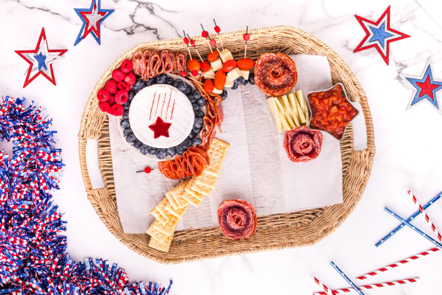 showing food being added to 4th of July Meat and Cheese Charcuterie Tray 