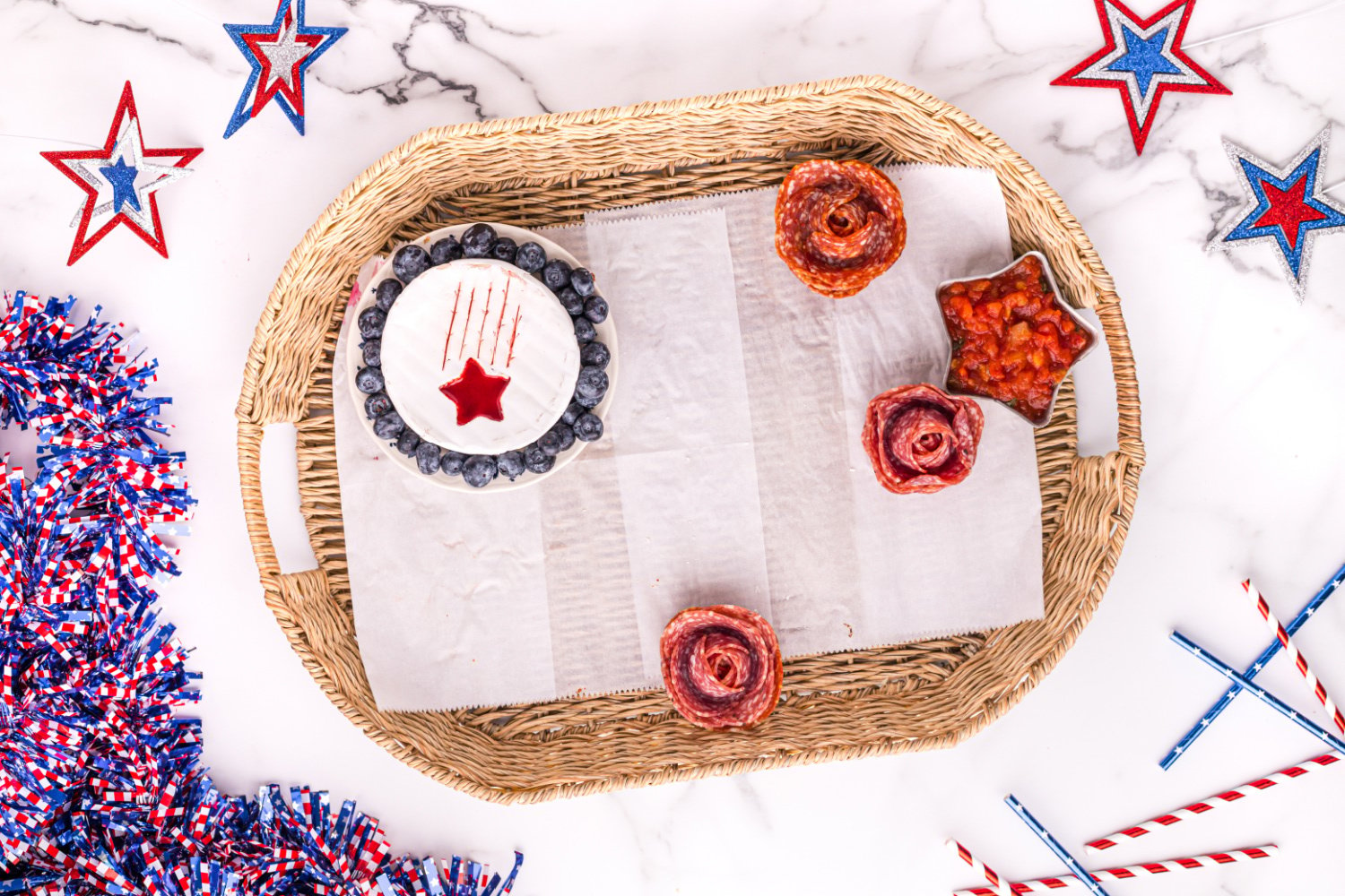 showing food being added to 4th of July Meat and Cheese Charcuterie Tray 