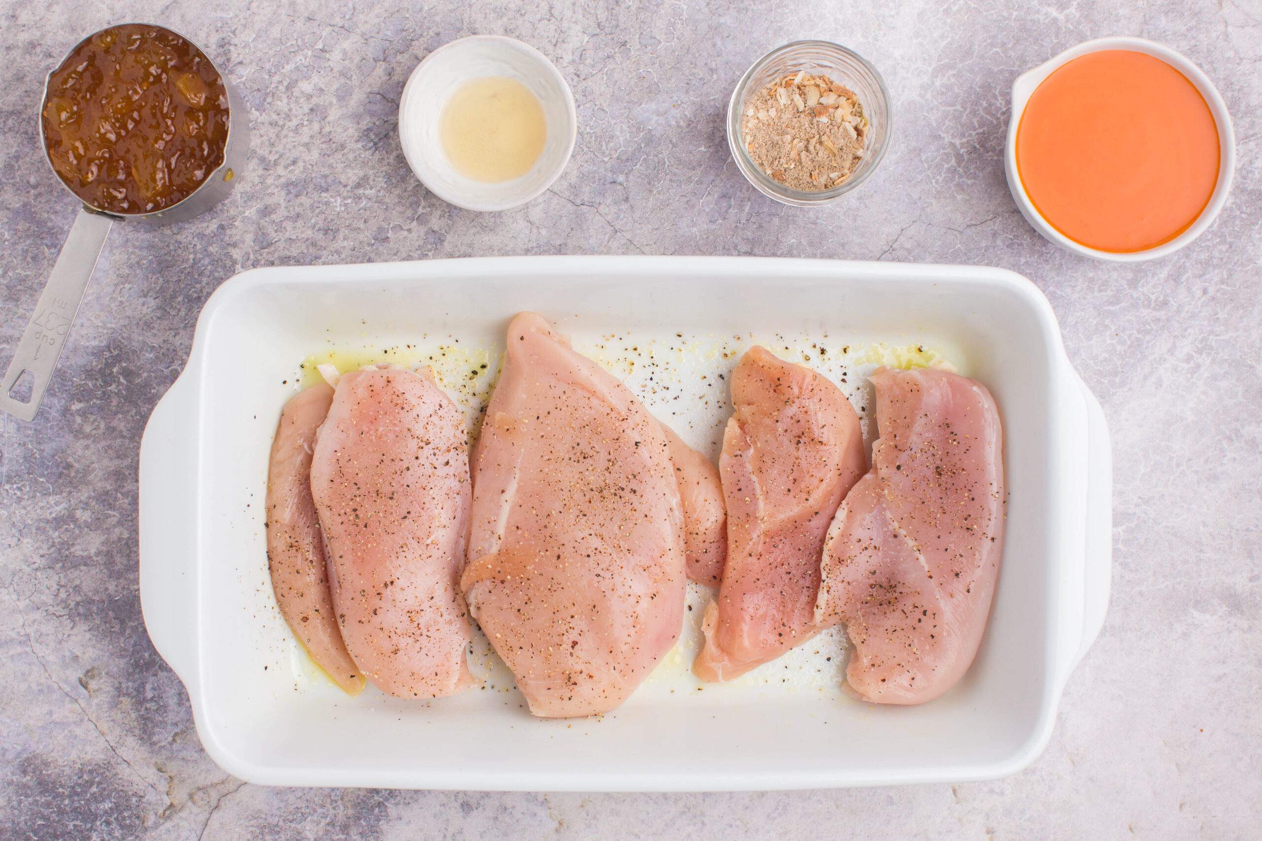 chicken breast in baking dish with seasoning