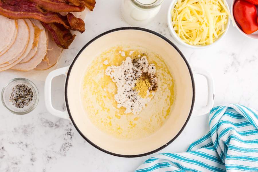 adding flour, about 1⁄2 teaspoon each of salt and pepper, ground mustard, and nutmeg to butter