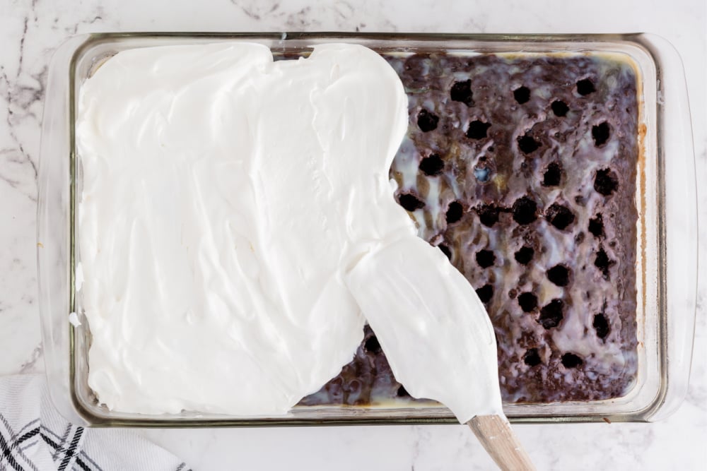 spreading cool whip over top of cake