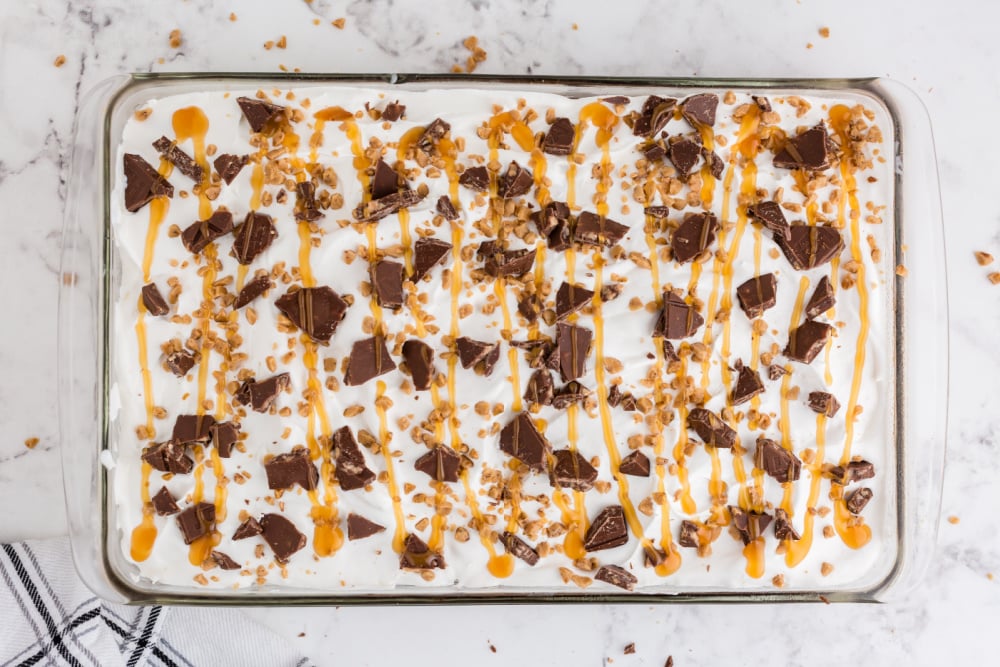 cake topped with snacks bar shit and caramel sauce