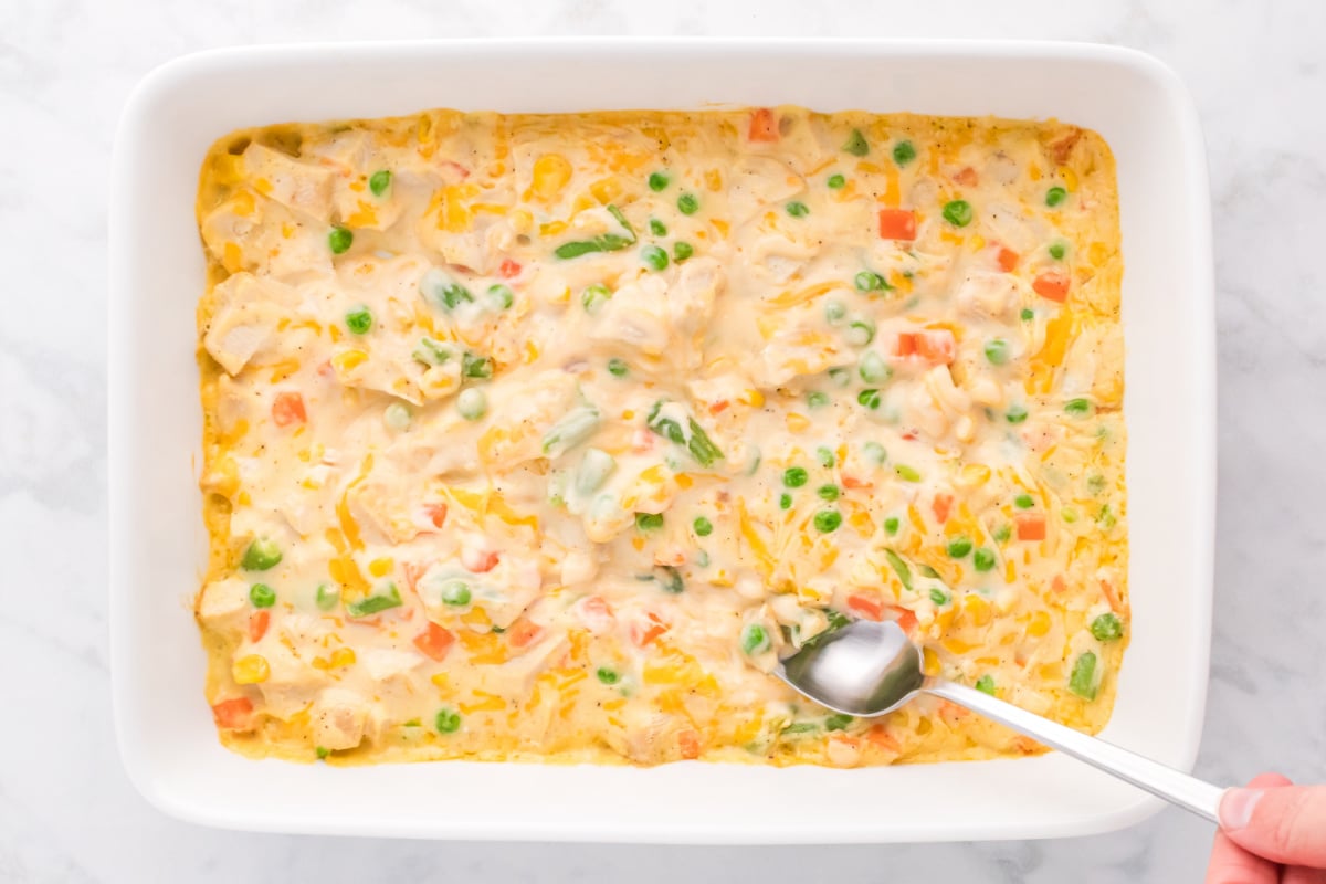 stirring chicken mixture in baking dish