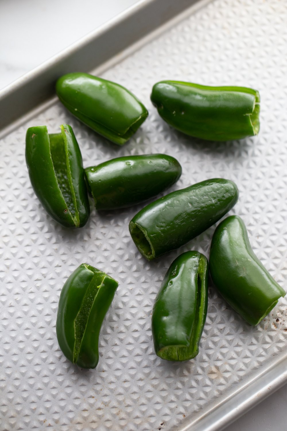 hallowed out jalapeños on baking dish 