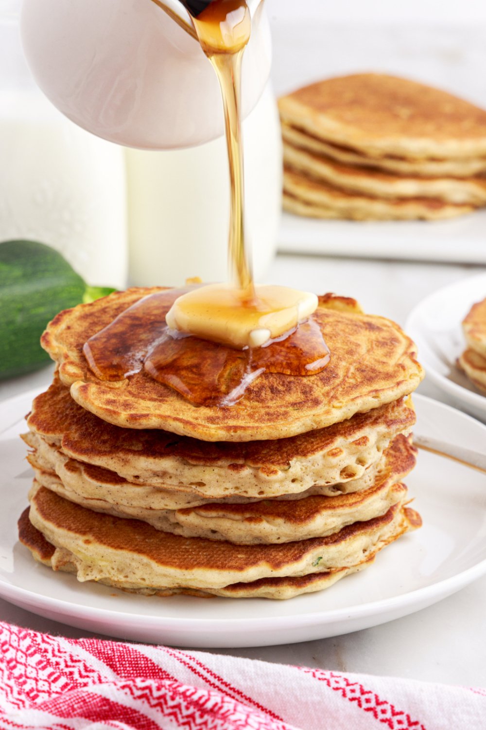 pouring syrup over pancakes