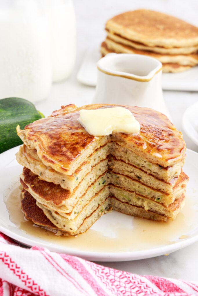 pancakes stacked on a plate with a piece cut out