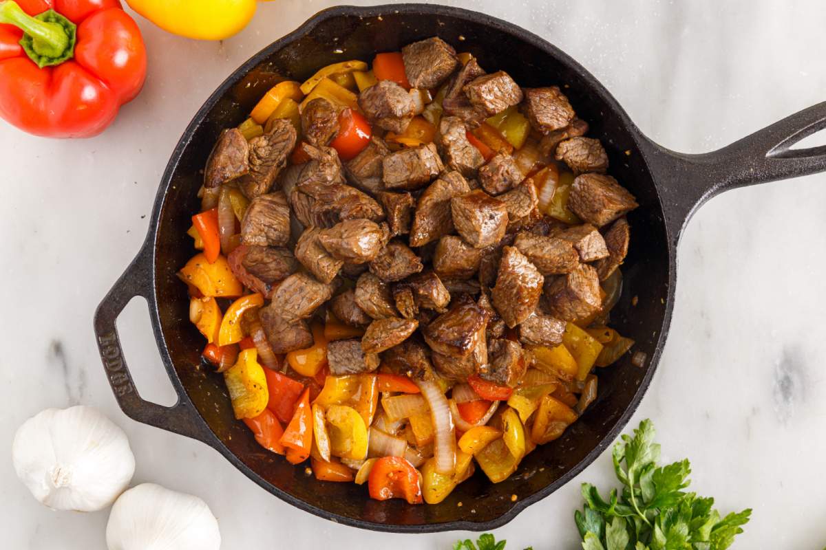 adding cooked steak back to pan