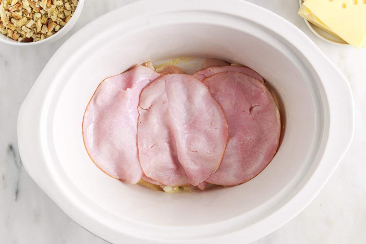 sliced ham placed on top of chicken