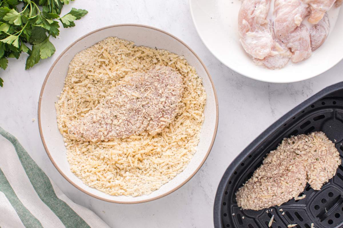 placing chicken in bread crumb mixture