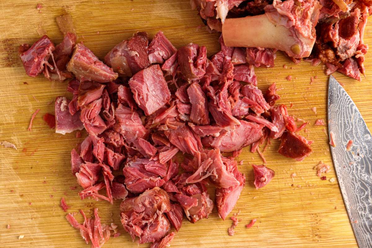 ham bone meat being cut on cutting board