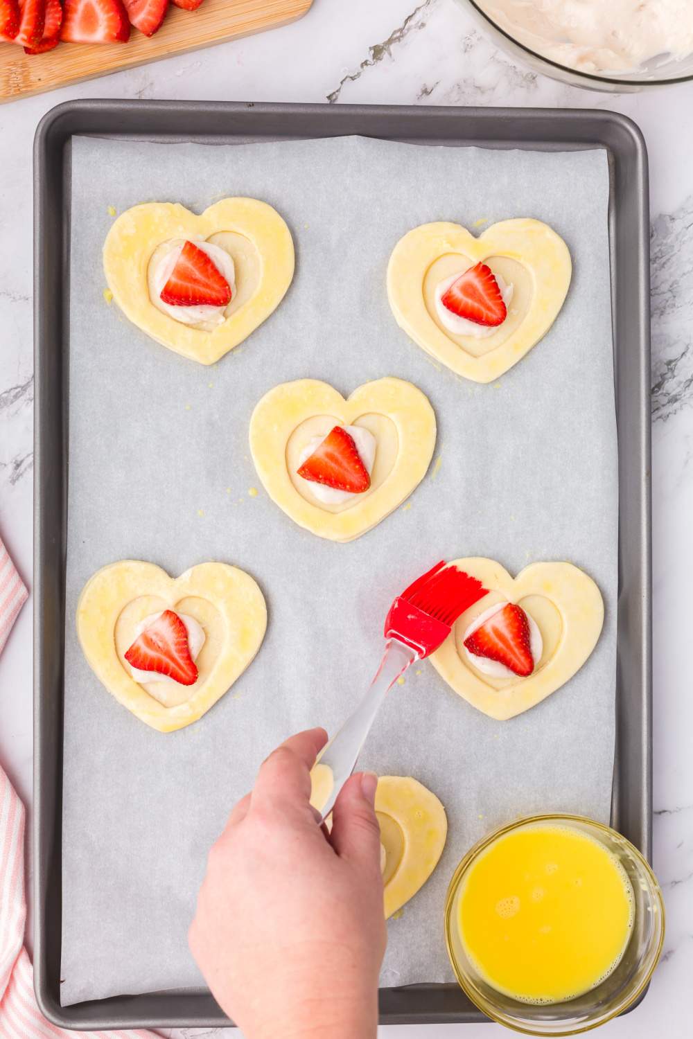 brushing edges of pastry hearts