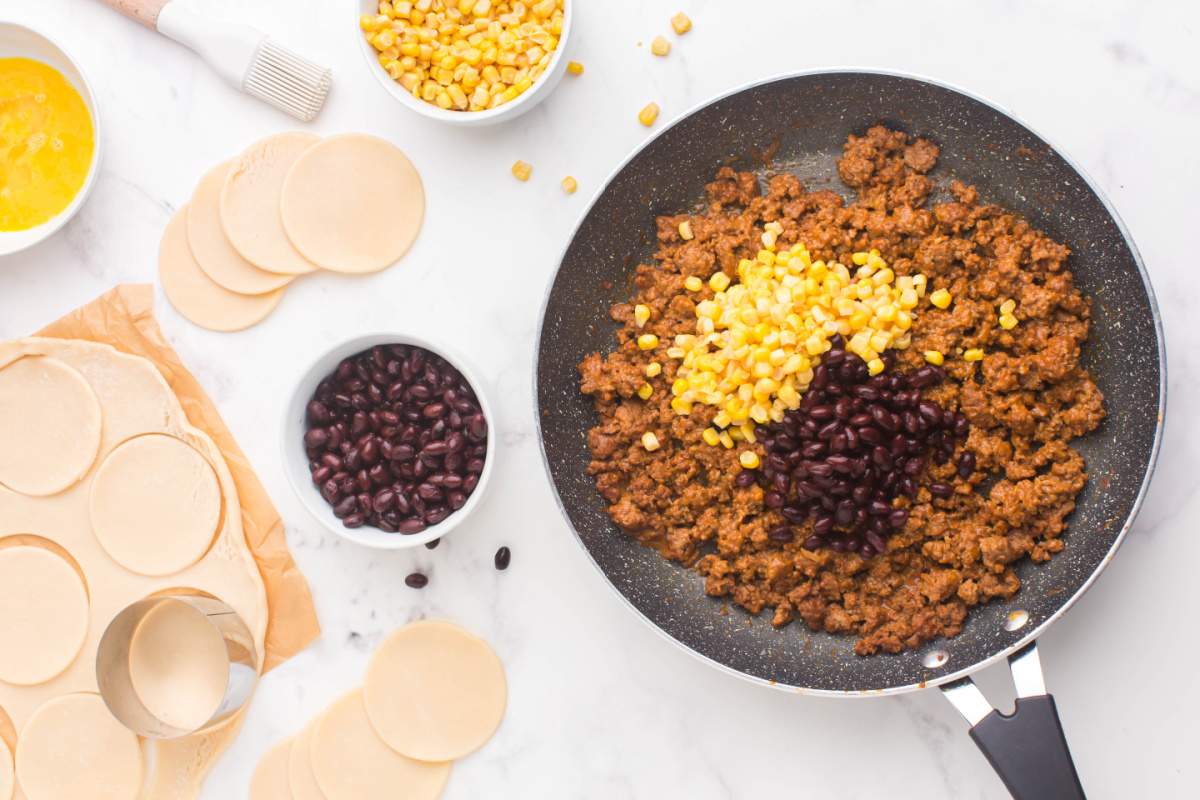 adding beans and corn to beef