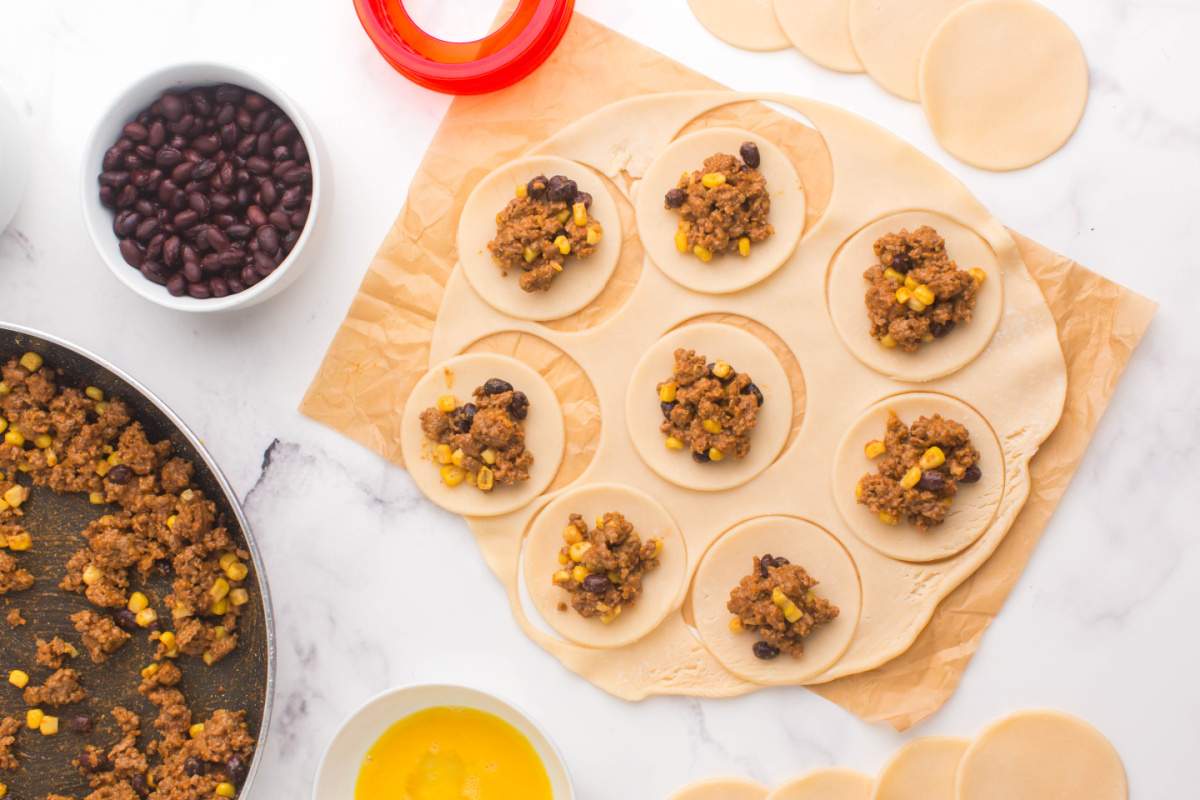 putting taco mixture on dough circles