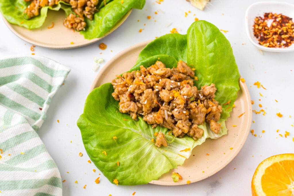 orange ground chicken on lettuce cup