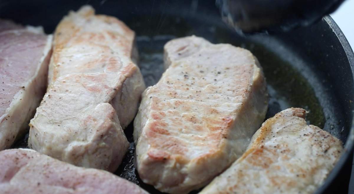 pork chops browning in pan