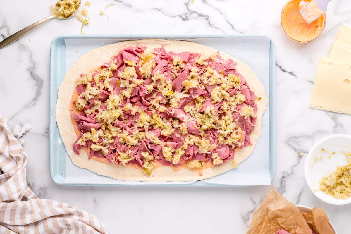 sauerkraut being added to top of corned beef