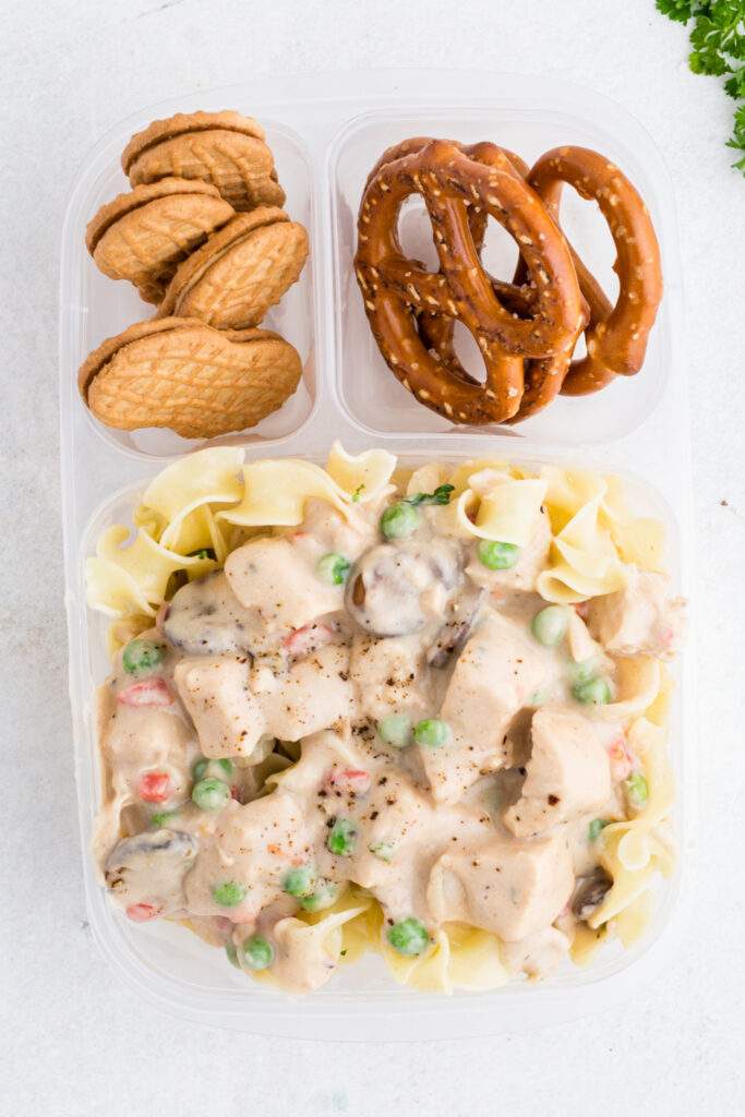 Chicken A La King packed in a lunchbox with pretzels and cookies