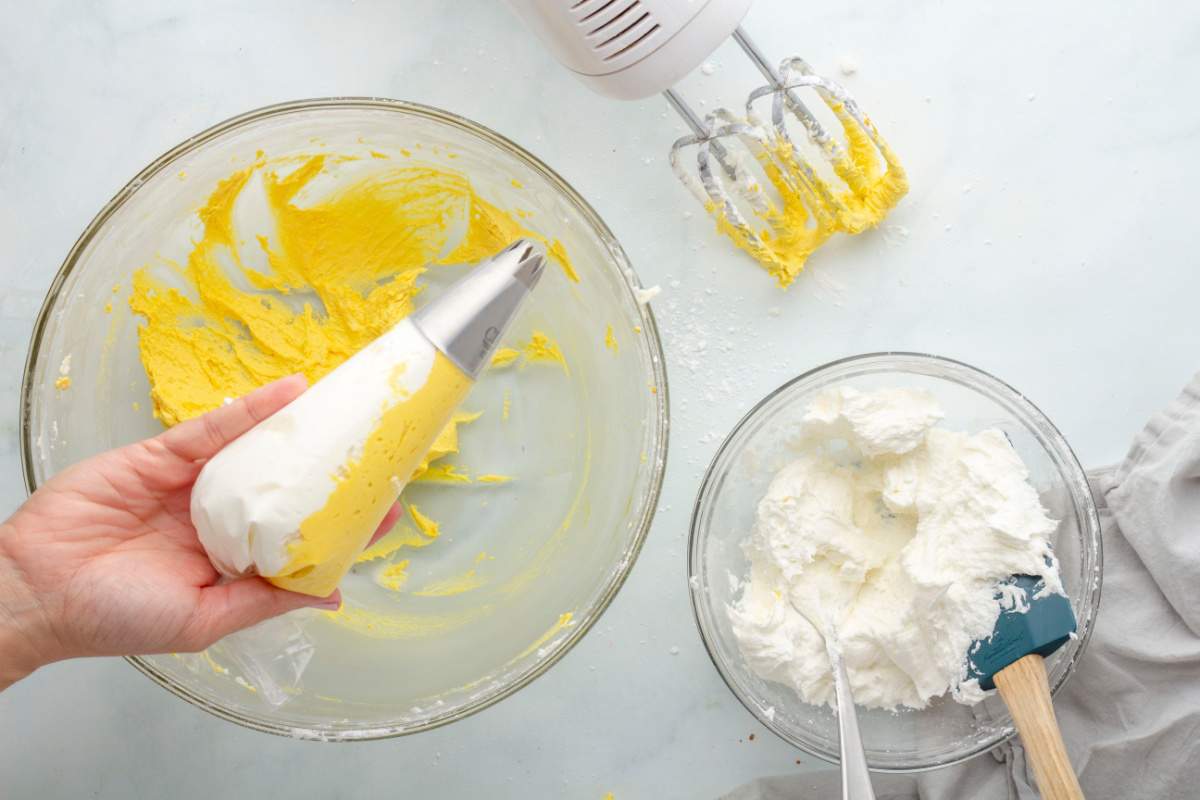 white and yellow frosting in pipping bag