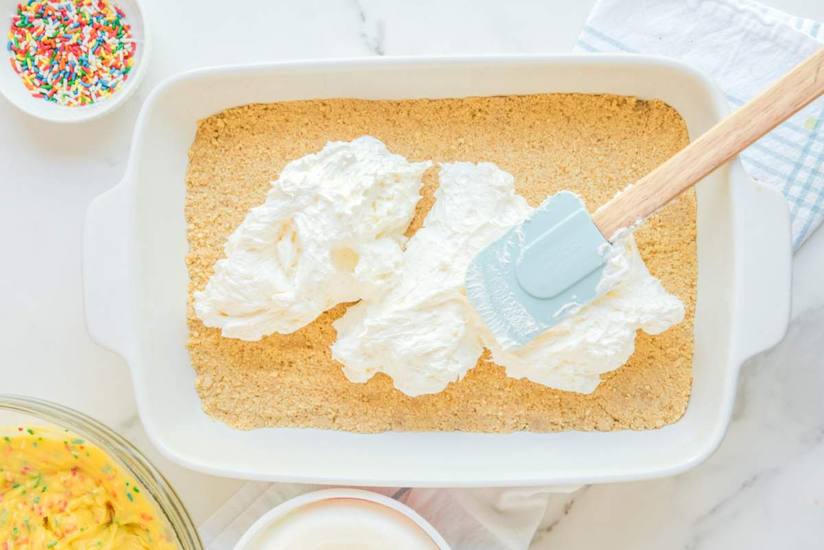 adding cream cheese mixture to the top of oreo crust