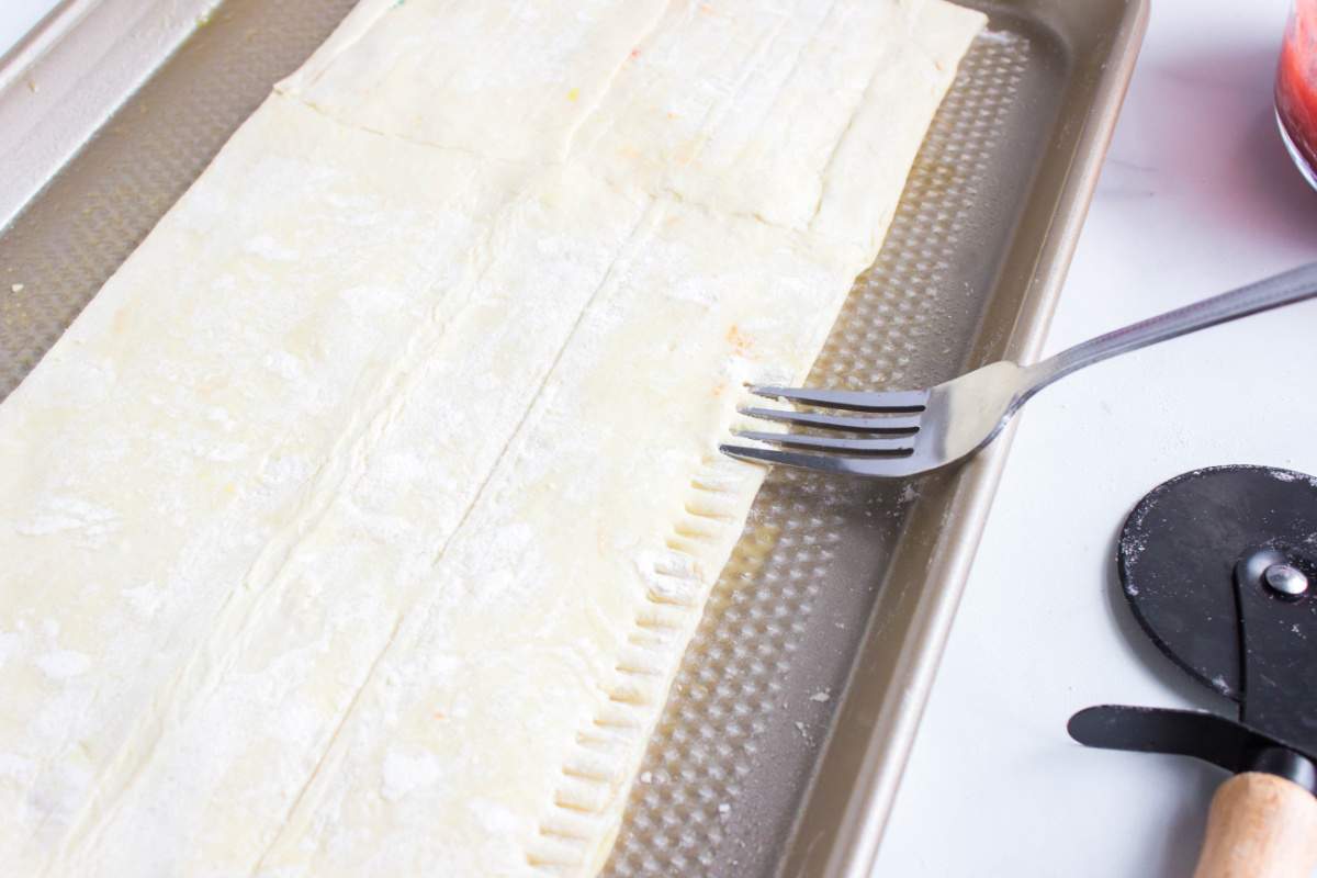 pressing the edge of the pastry with a fork
