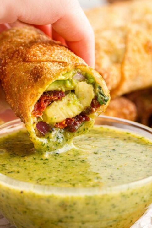 dipping Copycat Cheesecake Factory Avocado Egg Roll in sauce