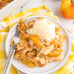 4 ingredient Peach Dump Cake on a plate with ice cream