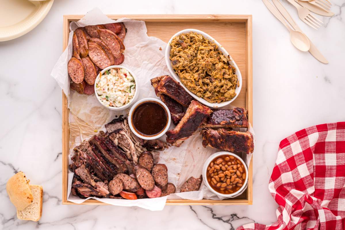 variety of bbq meats being added board