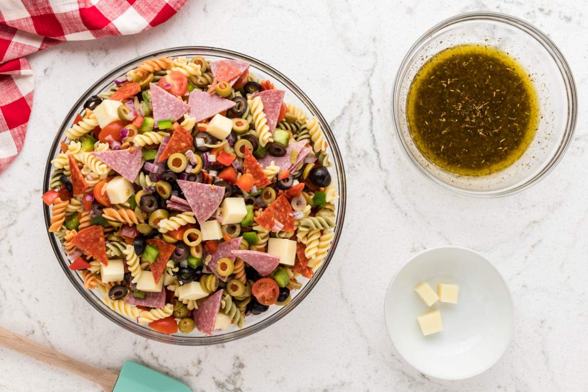 tossing pasta salad with dressing