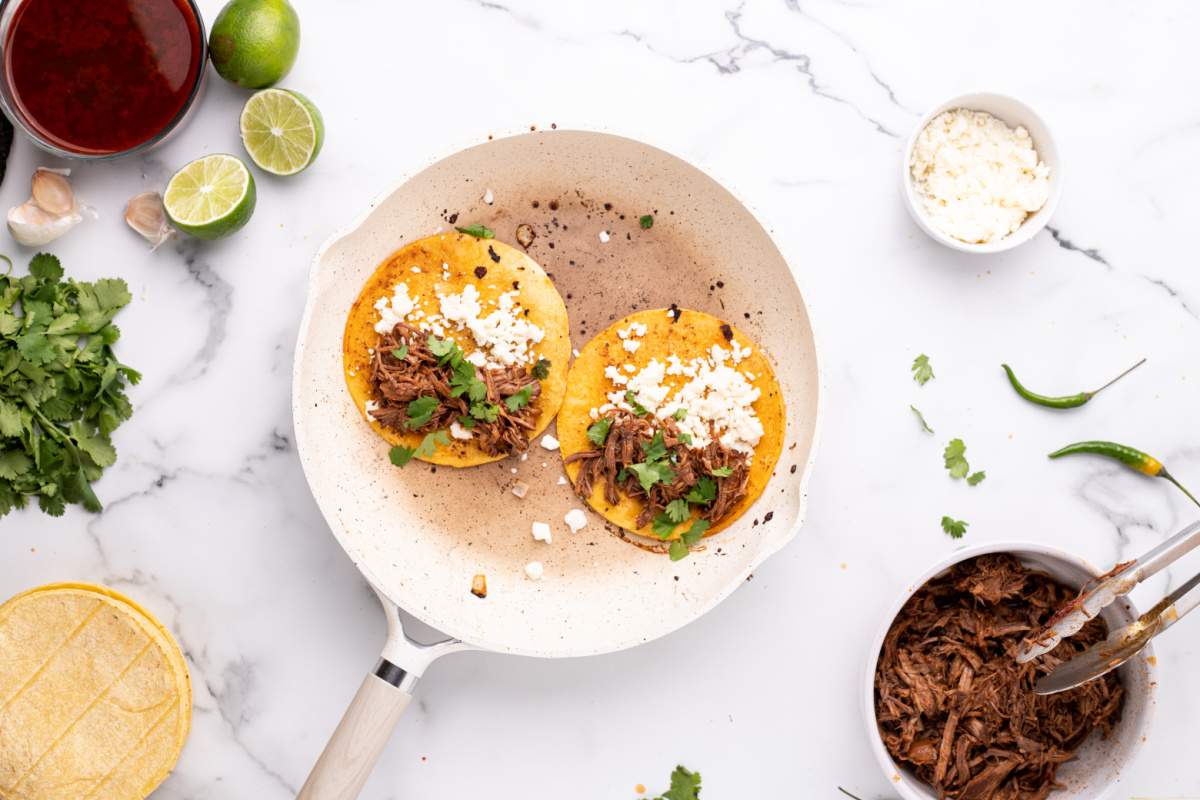 2 tortillas in a pan with beef, onion and cilantro