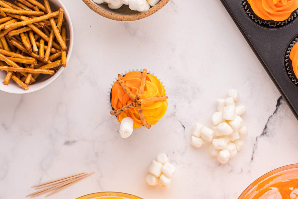 toothpick with mini marshmallows added to top of cupcake