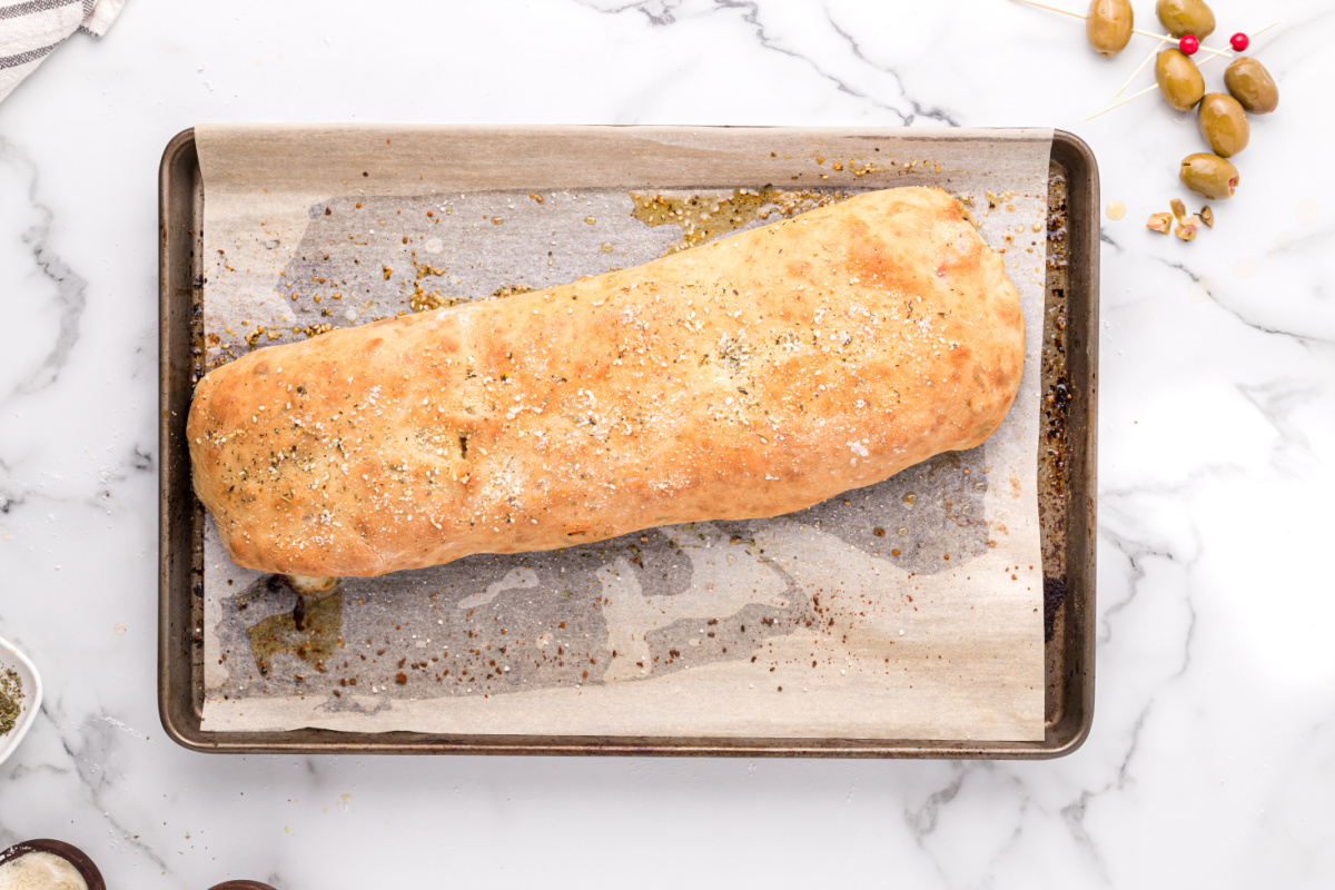 baked muffuletta garbage bread on a baking sheet