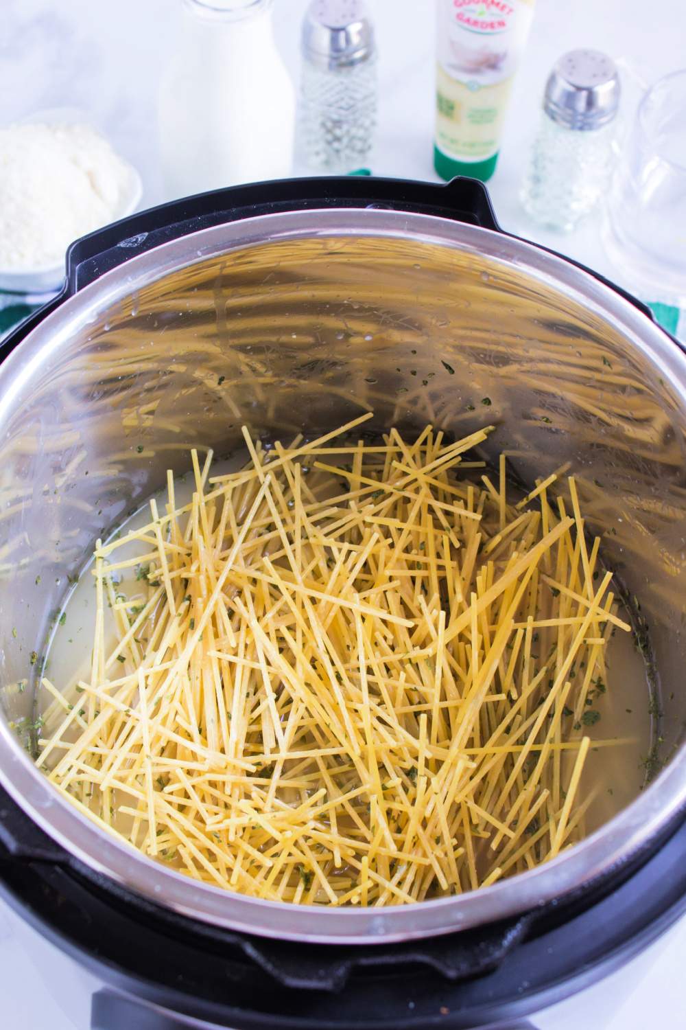 ingredients for Instant Pot Cheesy GarlicButter Spaghetti in to pressure cooker