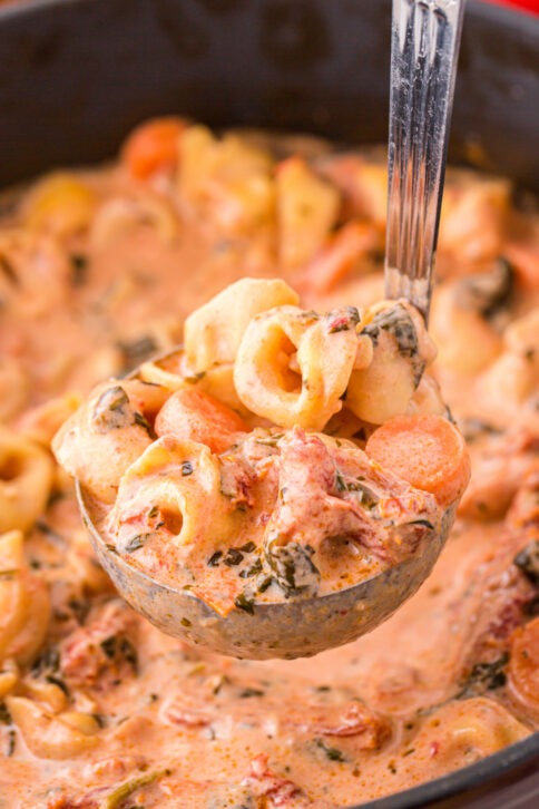 Creamy Tortellini Soup being scooped up with a laddle